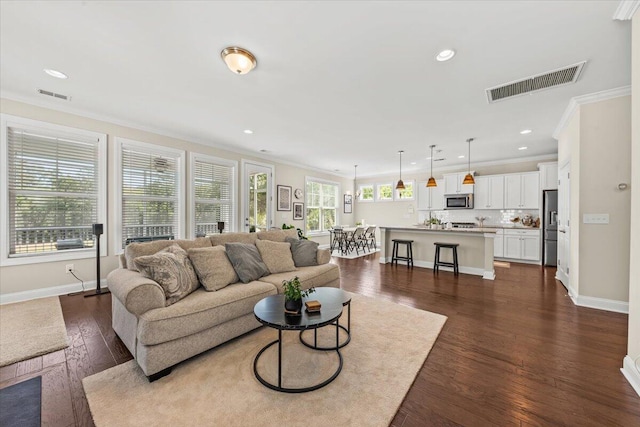 living room with crown molding, baseboards, recessed lighting, and dark wood finished floors