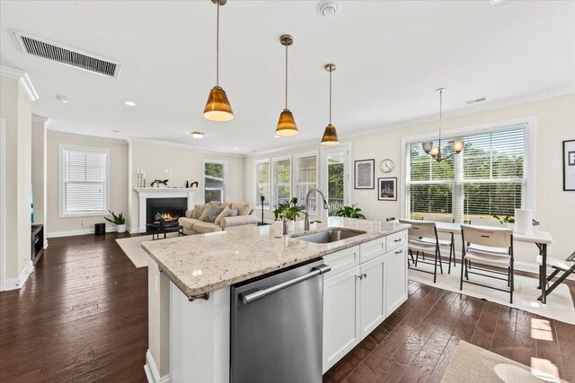 kitchen featuring stainless steel dishwasher, a sink, crown molding, a center island with sink, and dark wood-style flooring