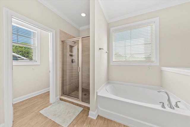 bathroom with crown molding, a shower stall, a bath, plenty of natural light, and wood finished floors
