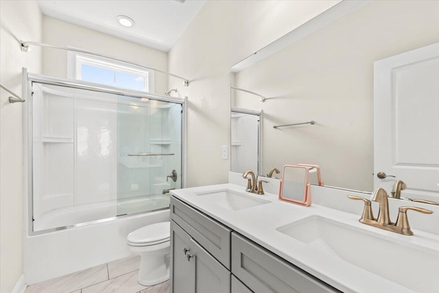 bathroom with bath / shower combo with glass door, toilet, and double vanity