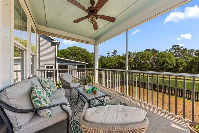 balcony with a ceiling fan, view of wooded area, and outdoor lounge area
