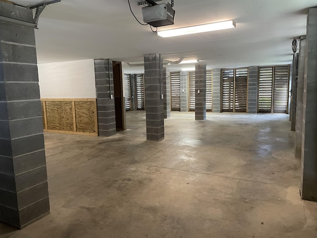 garage with a garage door opener and a wainscoted wall