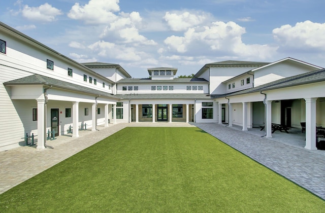 rear view of property featuring a lawn and a patio area