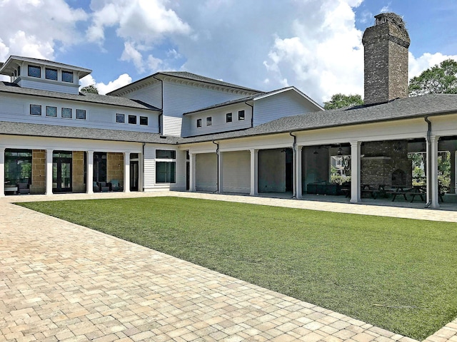 back of property with a chimney, a lawn, a patio area, and french doors