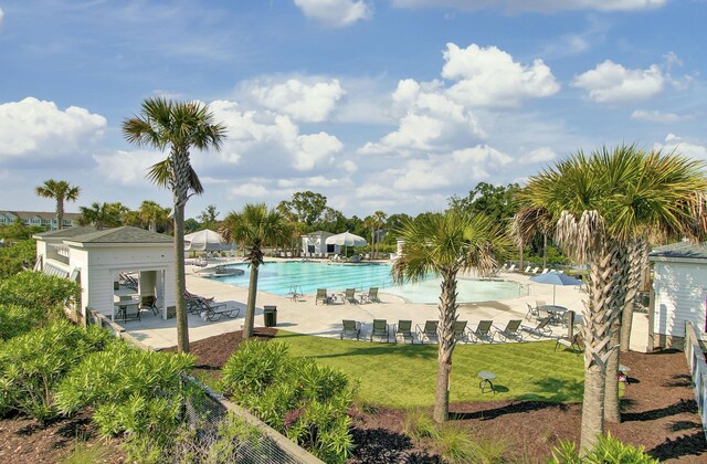 community pool with a patio and a lawn