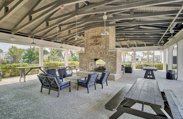 view of patio / terrace featuring a gazebo, an outdoor living space with a fireplace, and a ceiling fan