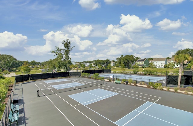 view of tennis court with community basketball court and fence