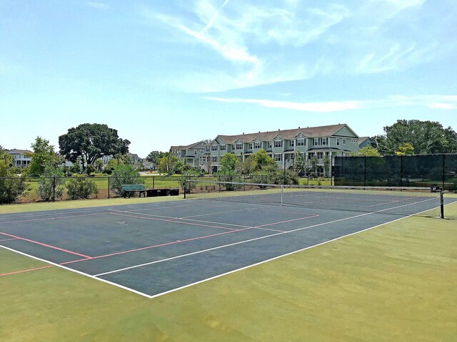 view of tennis court featuring fence and community basketball court