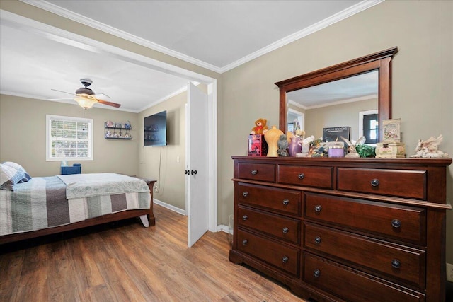 bedroom featuring crown molding, baseboards, light wood-type flooring, and ceiling fan