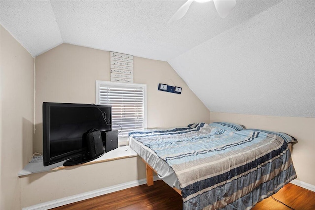 bedroom featuring lofted ceiling, wood finished floors, and a textured ceiling