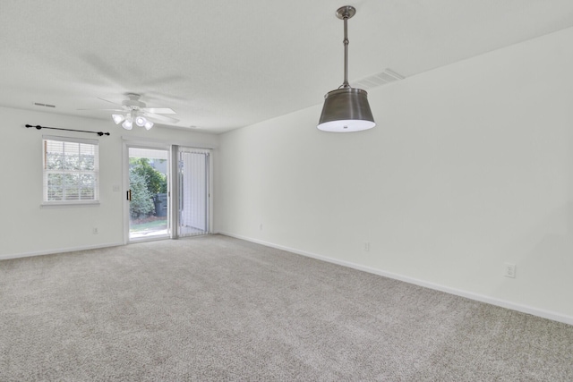 unfurnished room featuring carpet floors, ceiling fan, and baseboards