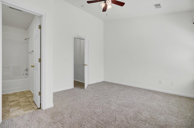 unfurnished bedroom featuring carpet floors, baseboards, ensuite bath, and a ceiling fan