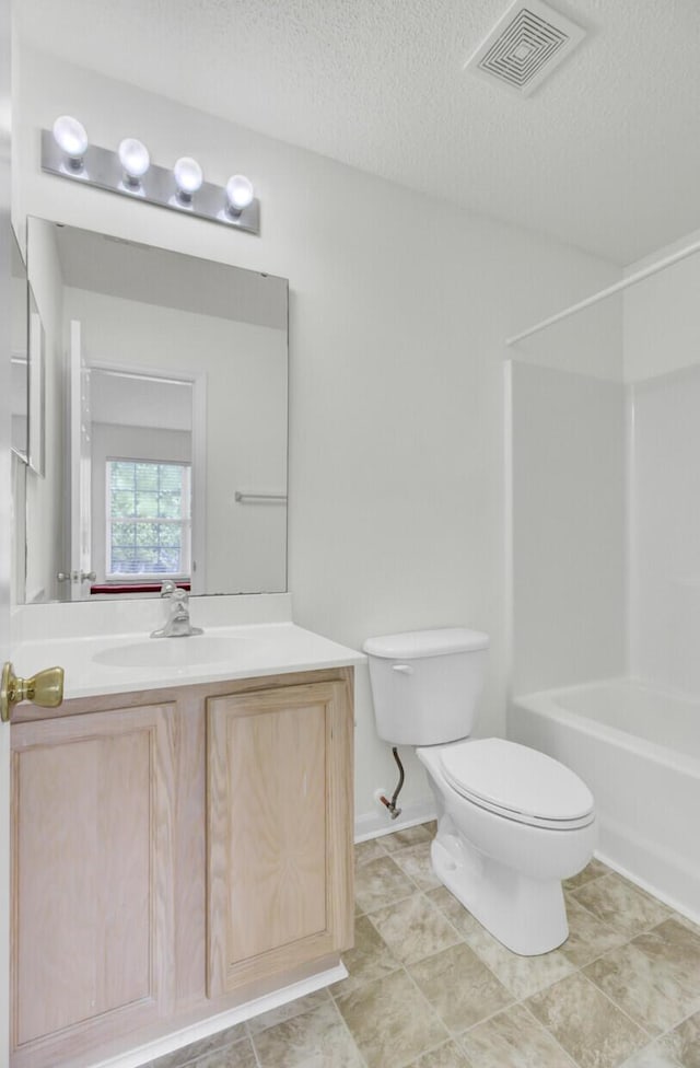 full bathroom featuring toilet, vanity, a textured ceiling, and bathing tub / shower combination