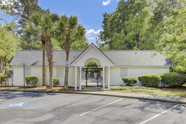 view of building exterior with uncovered parking and fence