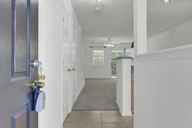 corridor featuring light tile patterned flooring, light carpet, baseboards, and recessed lighting