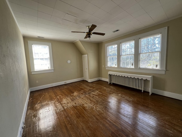 bonus room featuring visible vents, radiator, baseboards, a ceiling fan, and wood-type flooring