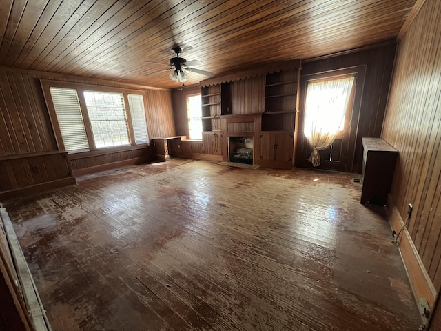 unfurnished living room featuring a fireplace with flush hearth, plenty of natural light, a ceiling fan, and wood-type flooring