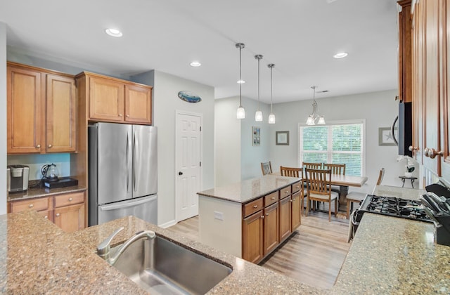 5433 Falling Tide, North Charleston, SC 29420 - kitchen featuring stainless steel appliances, a sink, light stone counters, a kitchen island, and light wood-style floors