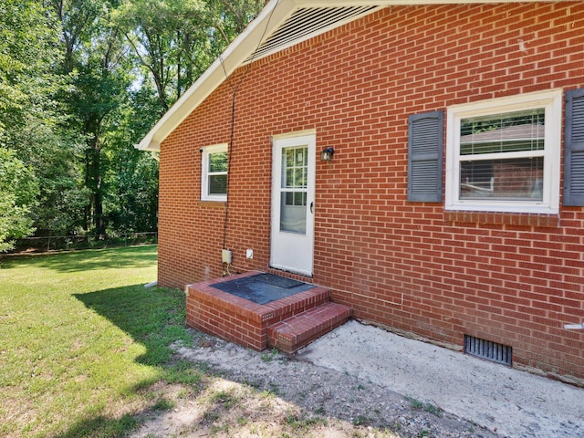 view of exterior entry with a lawn