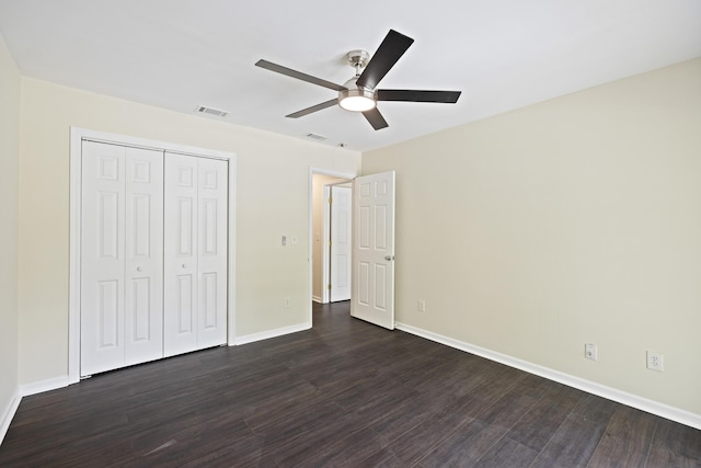 unfurnished bedroom featuring visible vents, baseboards, dark wood-style floors, ceiling fan, and a closet