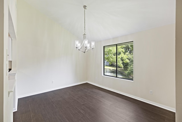 spare room with dark wood-style floors, baseboards, and a notable chandelier