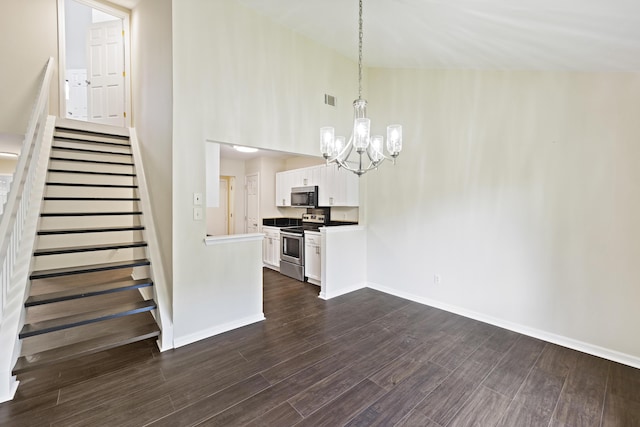 interior space featuring stainless steel electric range oven, hanging light fixtures, dark wood-style flooring, and white cabinets