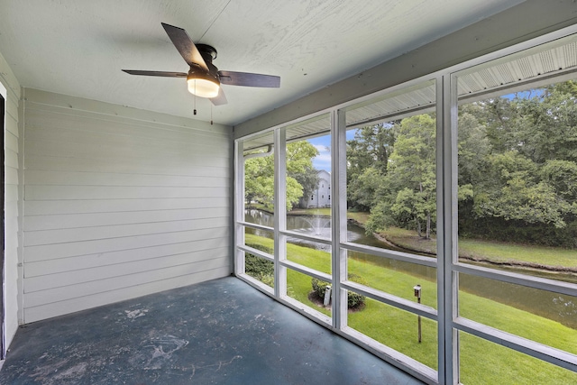 unfurnished sunroom with a water view and ceiling fan