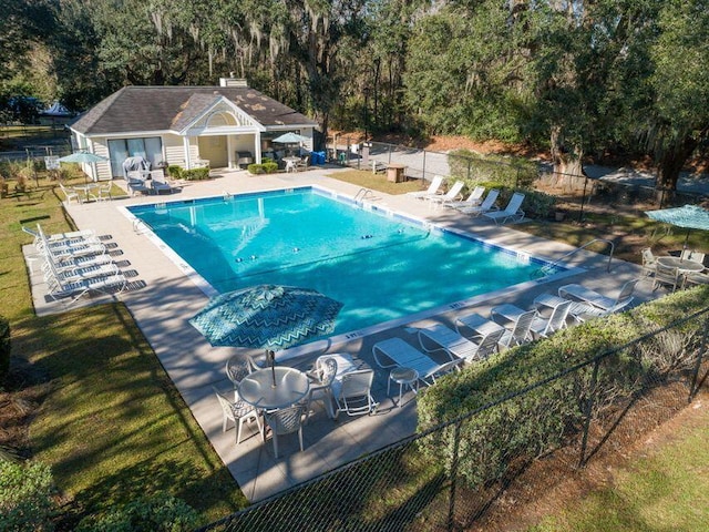 community pool featuring an exterior structure, a patio area, fence, and an outdoor structure