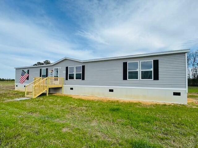 rear view of house with crawl space and a lawn