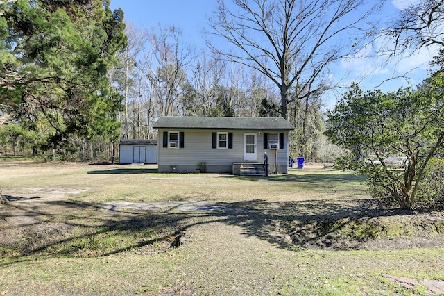 view of front of home featuring an outbuilding, a front lawn, and a shed