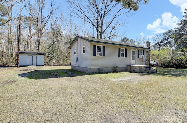 manufactured / mobile home with an outbuilding, cooling unit, a storage unit, dirt driveway, and crawl space