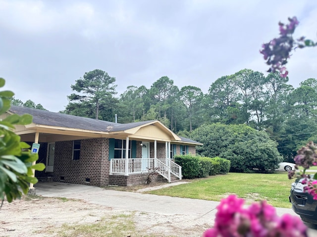 single story home with a carport, covered porch, and a front yard