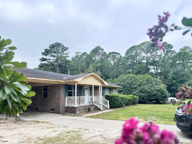 ranch-style home featuring a front yard, a carport, and a porch