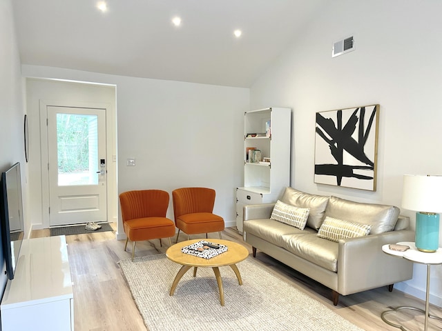 living room with high vaulted ceiling and light wood-type flooring