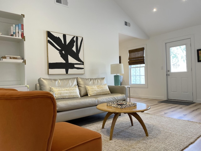 living room featuring vaulted ceiling and light hardwood / wood-style floors