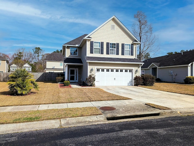 traditional-style house featuring an attached garage, driveway, a front lawn, and fence