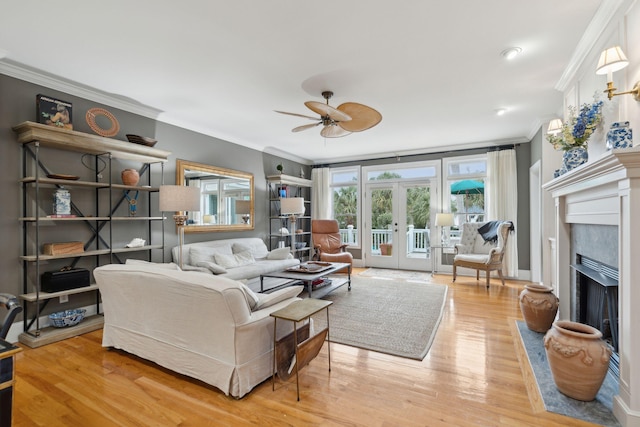 living room featuring french doors, ornamental molding, ceiling fan, and light hardwood / wood-style flooring