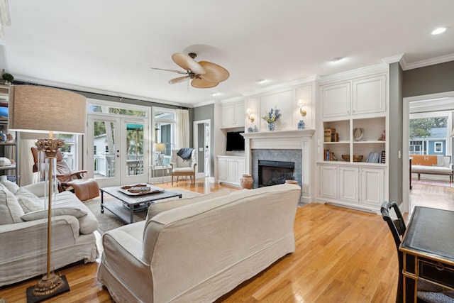 living room with light hardwood / wood-style flooring, ornamental molding, french doors, and ceiling fan