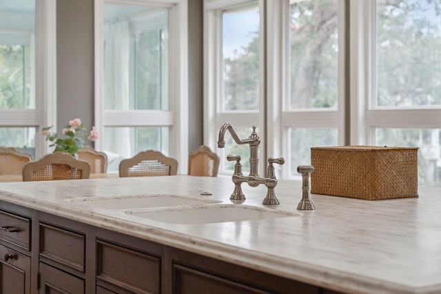 interior details featuring light stone countertops and sink