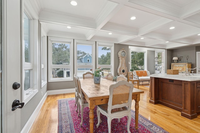 dining area featuring beamed ceiling, crown molding, coffered ceiling, and light wood-type flooring