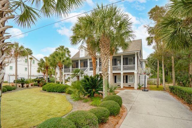 view of front of house featuring a balcony, a sunroom, and a front yard