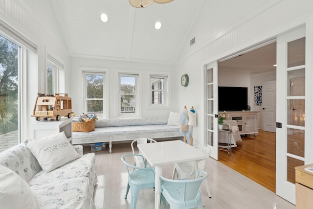 sunroom / solarium featuring lofted ceiling and a healthy amount of sunlight