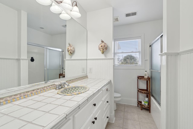 full bathroom featuring toilet, bath / shower combo with glass door, vanity, a notable chandelier, and tile patterned flooring