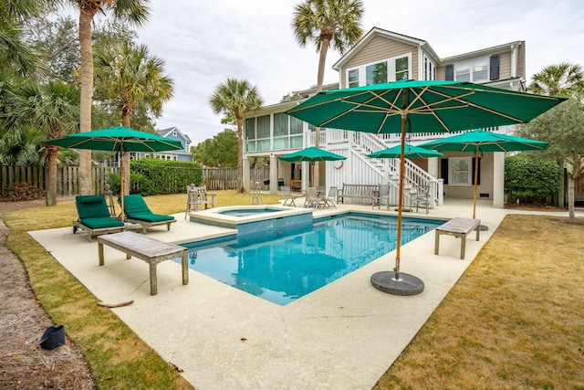 view of pool with an in ground hot tub, a patio, a sunroom, and a lawn