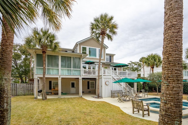 back of house featuring a fenced in pool, a yard, a sunroom, and a patio