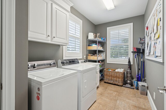 laundry area featuring washer and clothes dryer and cabinets