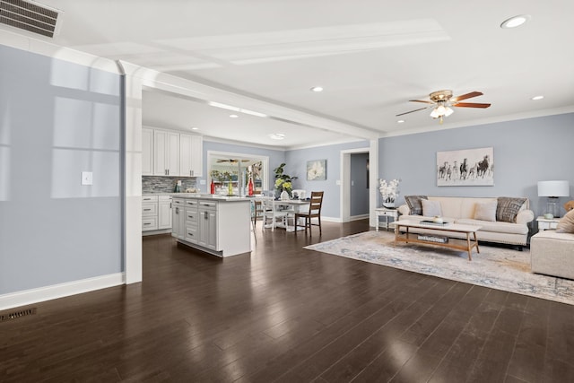 living room with ceiling fan, ornamental molding, and dark wood-type flooring