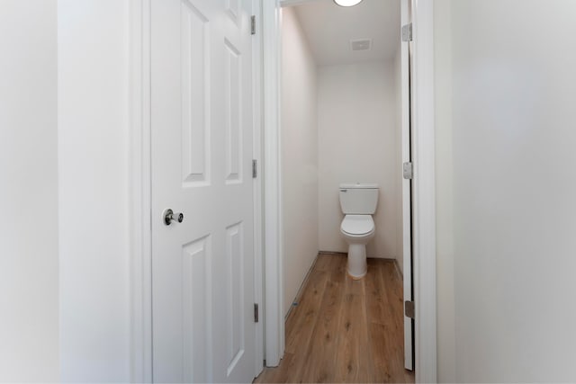 bathroom with toilet and hardwood / wood-style flooring