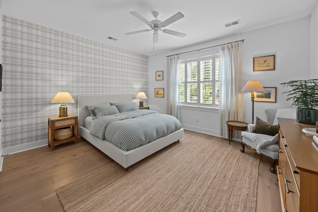 1557 Kepley Dr, Mount Pleasant, SC 29464 - bedroom featuring an accent wall, baseboards, wood finished floors, wallpapered walls, and a ceiling fan