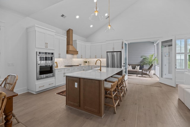 1557 Kepley Dr, Mount Pleasant, SC 29464 - kitchen with wall chimney range hood, a sink, appliances with stainless steel finishes, light wood-style flooring, and high vaulted ceiling